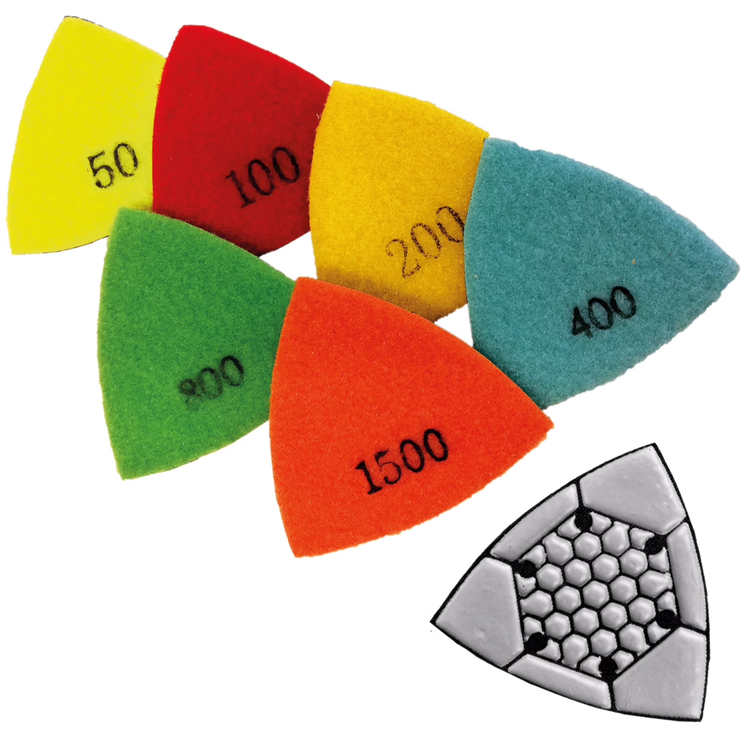 Un ensemble de tampons abrasifs triangulaires colorés pour un outil multifonction, disposés en chevauchement sur fond blanc. Chaque tampon d'aspect feutre a une couleur différente et porte des numéros de grain visibles (50, 100, 200, 400, 800, 1500). En bas à droite se voit une plaque abrasive triangulaire grise avec un motif alvéolé.
