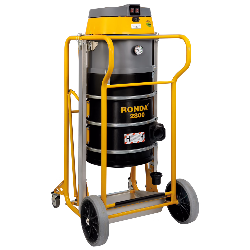 Un aspirateur industriel Ronda 2800 avec un dessus jaune et un corps cylindrique noir. Il possède un manomètre à l'avant, un grand conteneur de collecte et est monté sur un cadre robuste avec des roues pour la mobilité. Le design comprend une poignée pour un transport facile et convient aux tâches de nettoyage intensif.