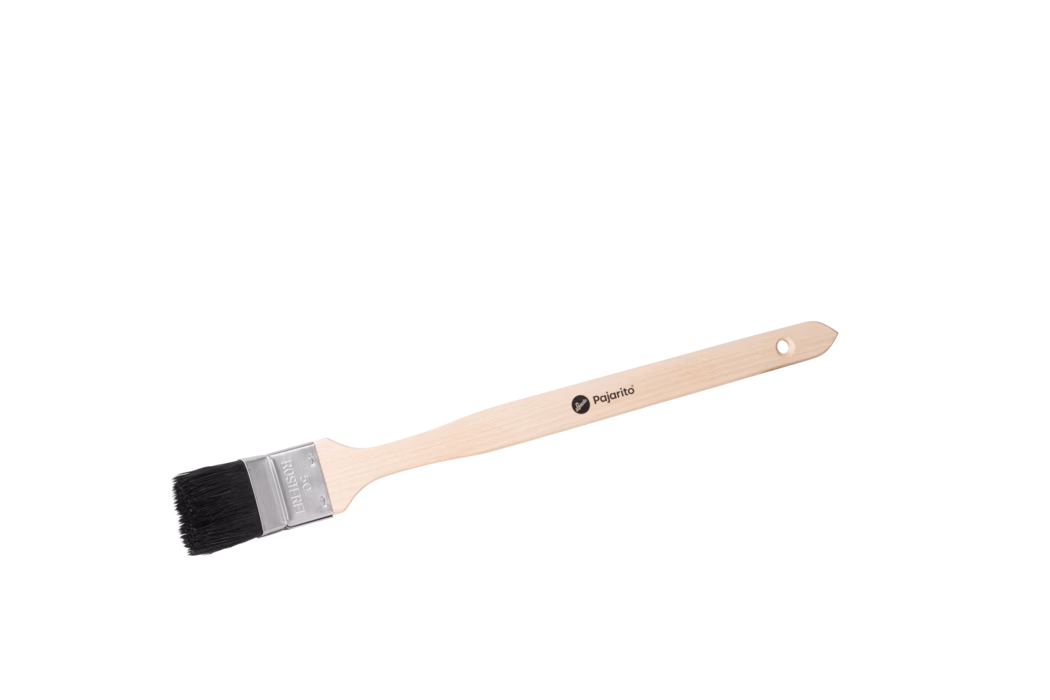 Pinceau long à manche en bois photographié sur un fond blanc épuré. Le manche en hêtre clair est fin et ergonomique, avec un petit trou rond à l'extrémité pour le suspendre et le logo noir 'pajarito' imprimé sur la tige. Une virole métallique argentée, sertie, maintient des poils courts et noirs ; la virole est marquée '50' et 'ROSTFREI', indiquant vraisemblablement une largeur de 50 mm et une construction inoxydable. Le pinceau est présenté en diagonale, mettant en valeur la texture du bois, les pointes nettes des poils et la ferrure métallique ; il semble neuf et non utilisé, adapté aux bords, plinthes et travaux de précision.